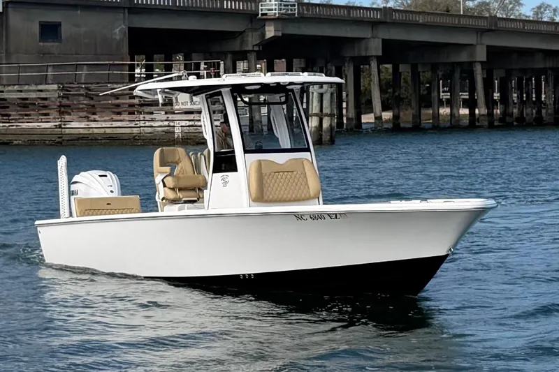 Slide: The Image of 2023 Sportsman Masters 267 Bay Boat cruising on water near a bridge. - 10