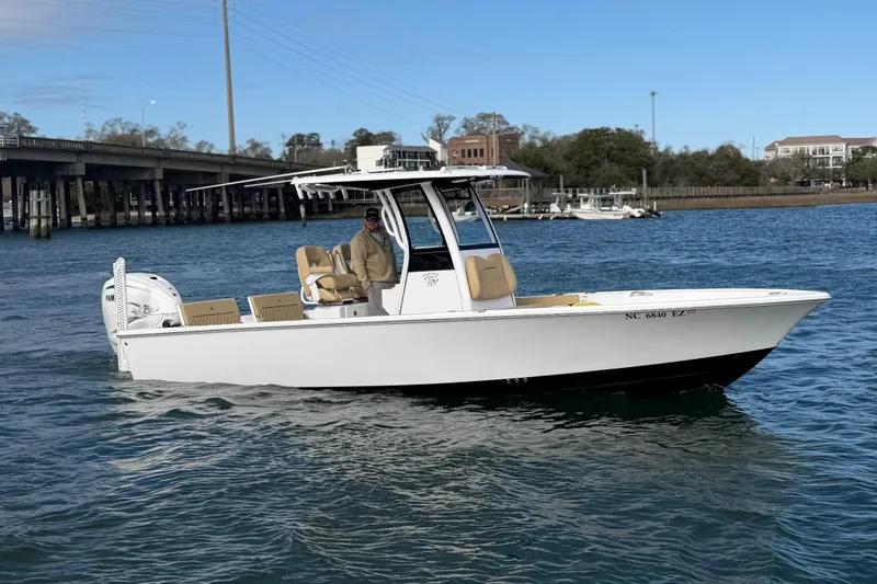 Slide: The Image of 2023 Sportsman Masters 267 Bay Boat cruising on a calm river near a bridge. - 11