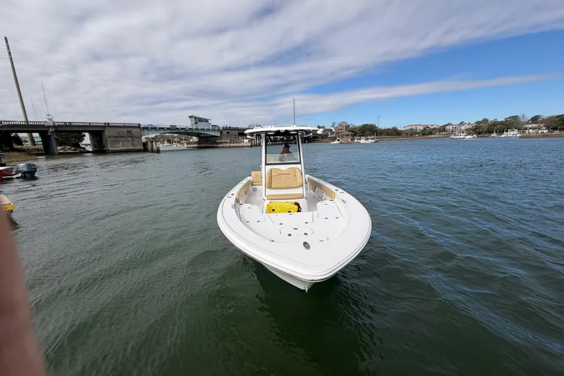 Slide: The Image of 2023 Sportsman Masters 267 Bay Boat on calm water near a bridge. - 19