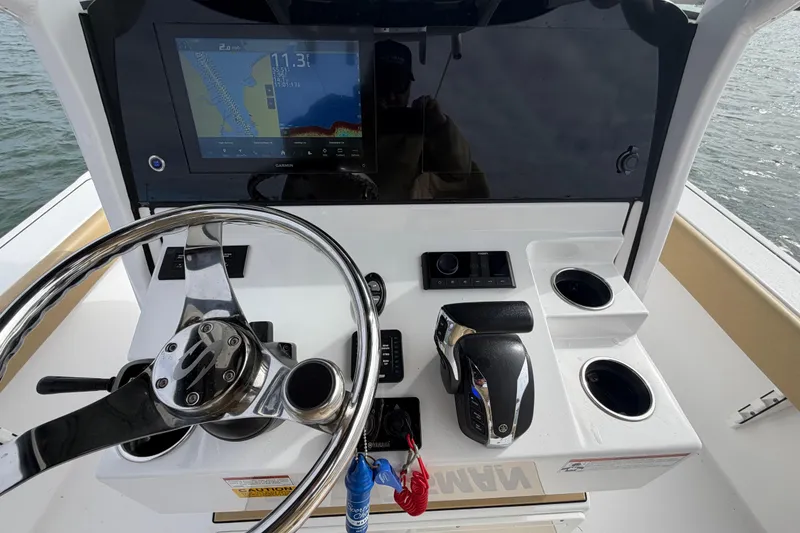 Slide: The Image of 2023 Sportsman Masters 267 Bay Boat dashboard with steering wheel and navigation display. - 20