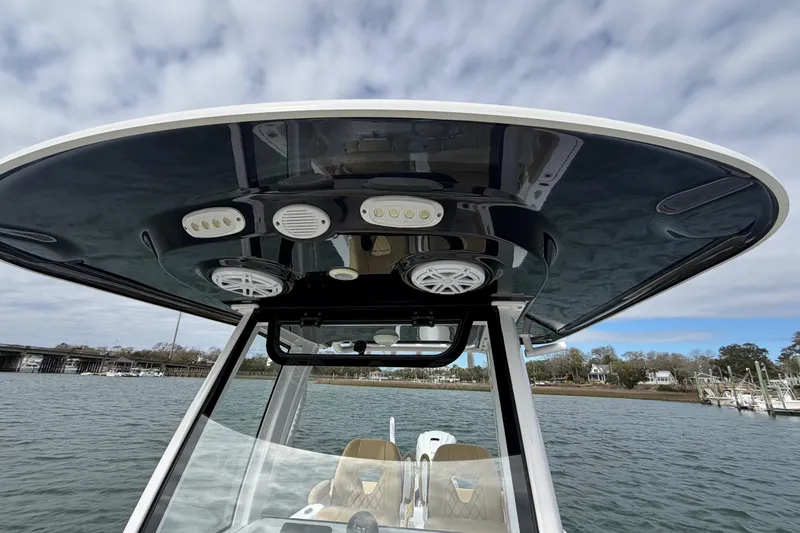 Slide: The Image of 2023 Sportsman Masters 267 Bay Boat T-top with speakers and lights on a cloudy day. - 21