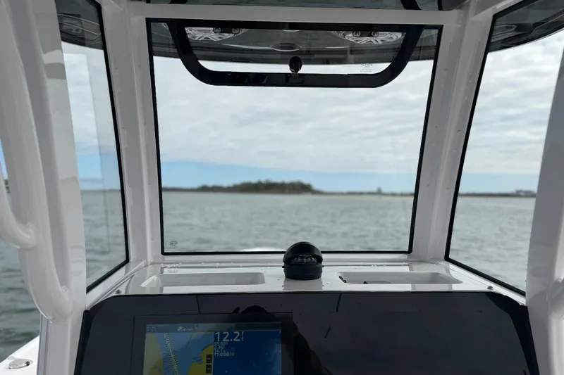 Slide: The Image of 2023 Sportsman Masters 267 Bay Boat dashboard view with navigation screen and compass. - 22