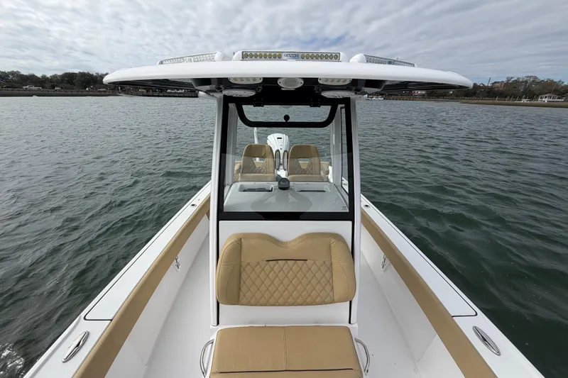 Slide: The Image of 2023 Sportsman Masters 267 Bay Boat on water, featuring tan seating and sleek design. - 26