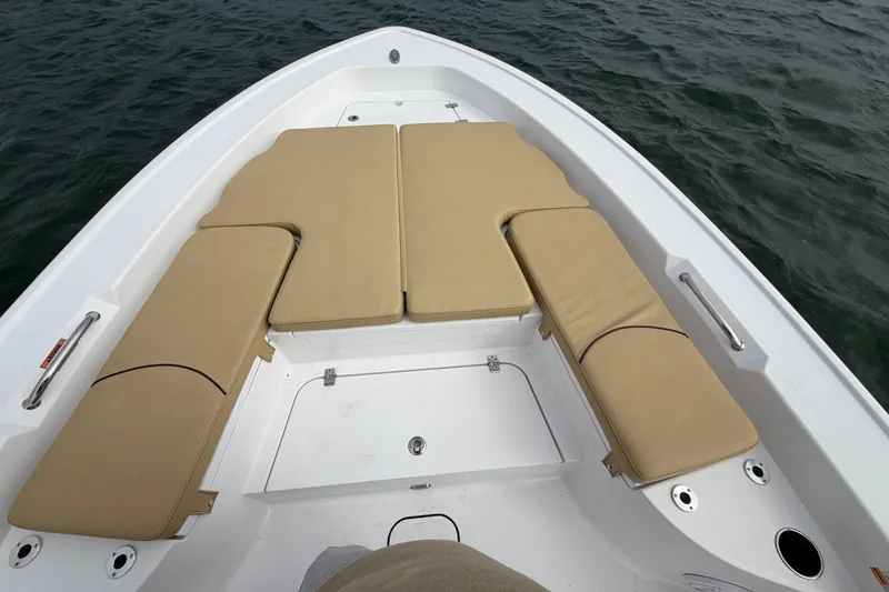 Slide: The Image of 2023 Sportsman Masters 267 Bay Boat with tan cushioned seating on calm water. - 27