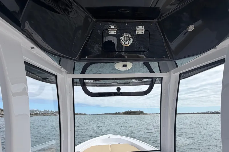 Slide: The Image of 2023 Sportsman Masters 267 Bay Boat interior view with water and sky background. - 31