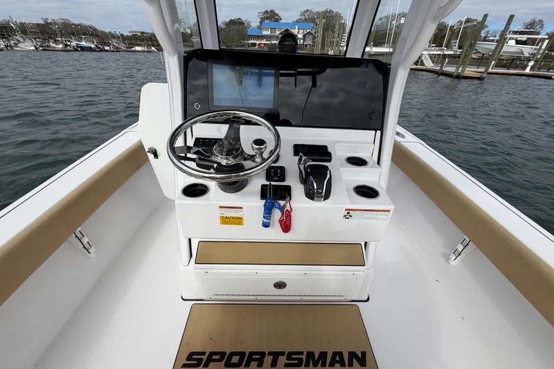 Slide: The Image of 2023 Sportsman Masters 267 Bay Boat helm with steering wheel and controls on water. - 41