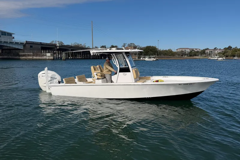 Slide: The Image of 2023 Sportsman Masters 267 Bay Boat cruising on a sunny day near a bridge. - 6