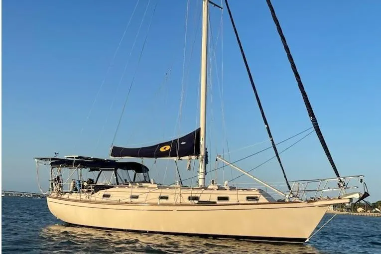 The Image of 1996 Island Packet 40 sailboat on calm water under clear blue sky. - 0