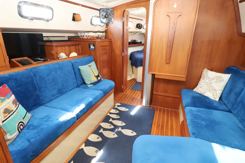 Slide: The Image of Interior of a 1996 Island Packet 40 yacht with blue seating and nautical decor. - 13