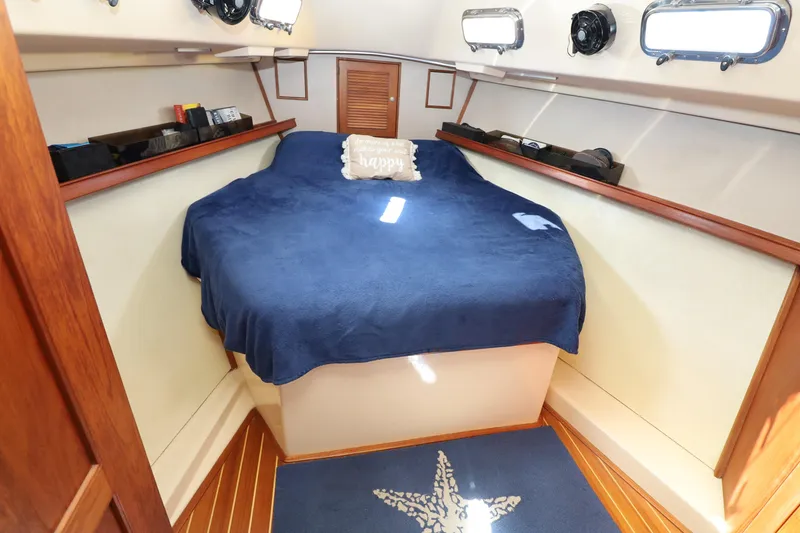 Slide: The Image of Cozy cabin interior of 1996 Island Packet 40 sailboat with blue bedding and nautical decor. - 14