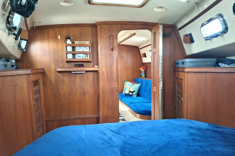 Slide: The Image of Interior of a 1996 Island Packet 40 sailboat with wooden cabinetry and blue upholstery. - 15