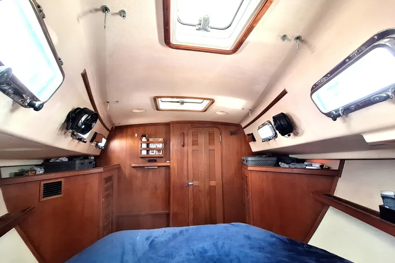 Slide: The Image of Interior cabin of a 1996 Island Packet 40 sailboat with wooden finishes and portholes. - 16