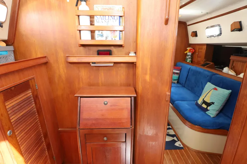 Slide: The Image of Interior of 1996 Island Packet 40 sailboat with wooden cabinetry and blue seating. - 17