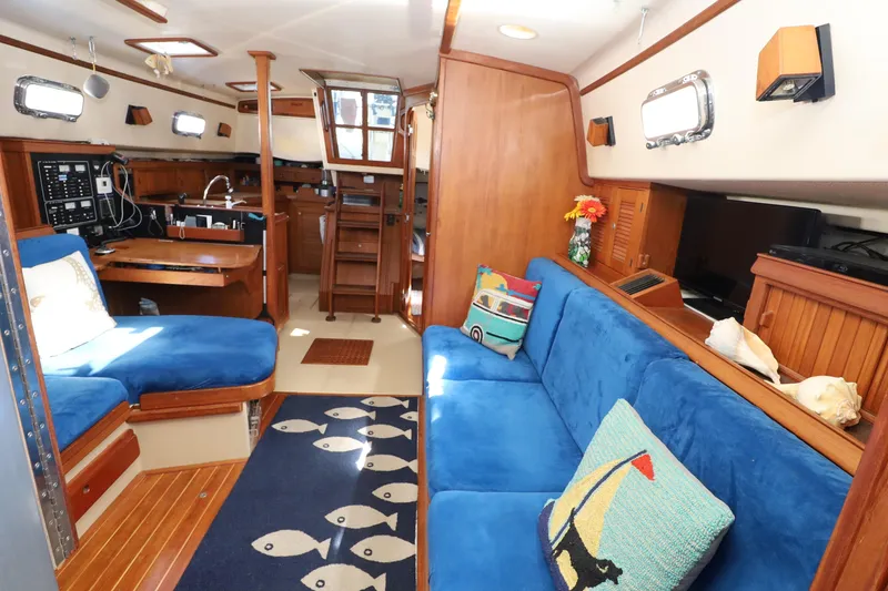 Slide: The Image of Interior of 1996 Island Packet 40 sailboat with blue seating and nautical decor. - 18