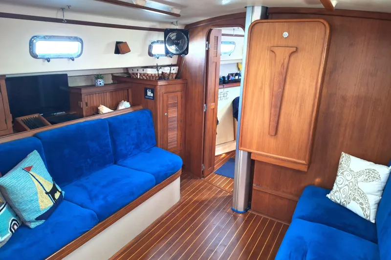 Slide: The Image of Interior of 1996 Island Packet 40 yacht with blue seating and wooden accents. - 19