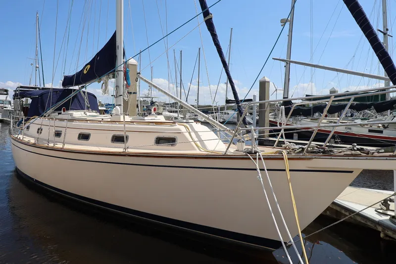 Slide: The Image of 1996 Island Packet 40 sailboat docked at marina under clear blue sky. - 2