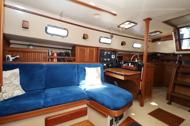 Slide: The Image of Interior of a 1996 Island Packet 40 sailboat with blue seating and wooden cabinetry. - 20