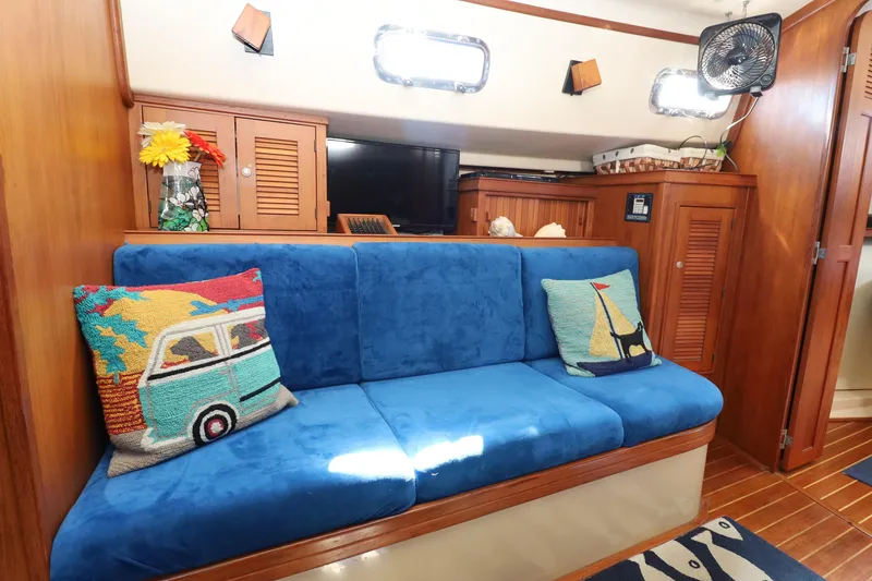 Slide: The Image of Interior of 1996 Island Packet 40 sailboat with blue sofa and nautical-themed pillows. - 21
