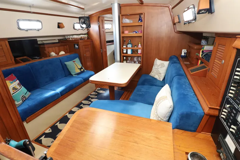 Slide: The Image of Interior of 1996 Island Packet 40 sailboat with blue seating and wooden accents. - 22