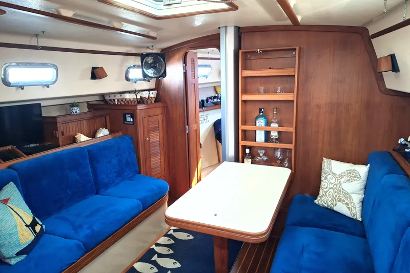 Slide: The Image of Interior of 1996 Island Packet 40 yacht with blue seating and wooden cabinetry. - 24