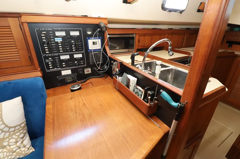 Slide: The Image of Interior of a 1996 Island Packet 40 sailboat featuring a navigation station and galley area. - 25