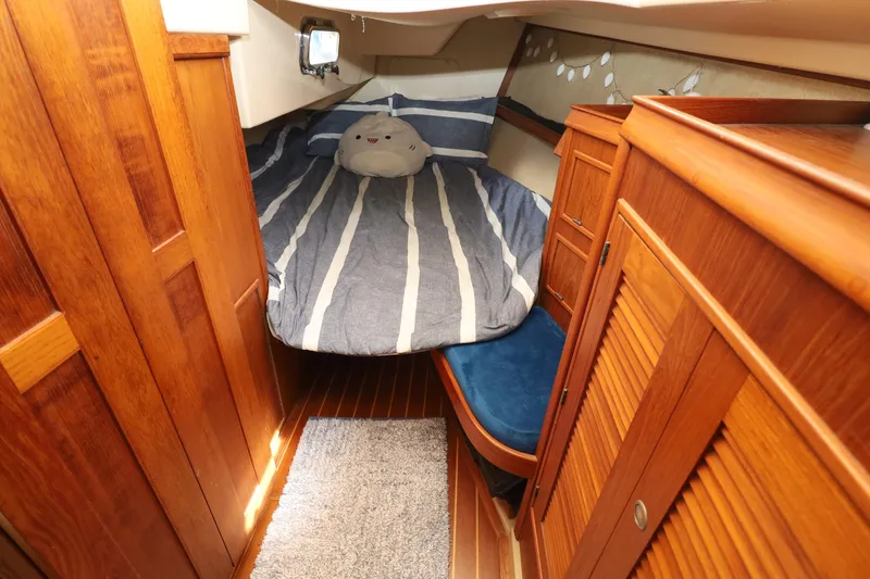 Slide: The Image of Cozy cabin interior of 1996 Island Packet 40 sailboat with striped bedding and wooden furnishings. - 29