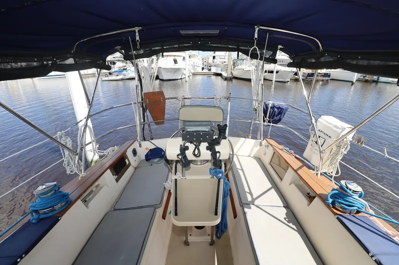 Slide: The Image of Cockpit of a 1996 Island Packet 40 sailboat, featuring seating and navigation equipment. - 32