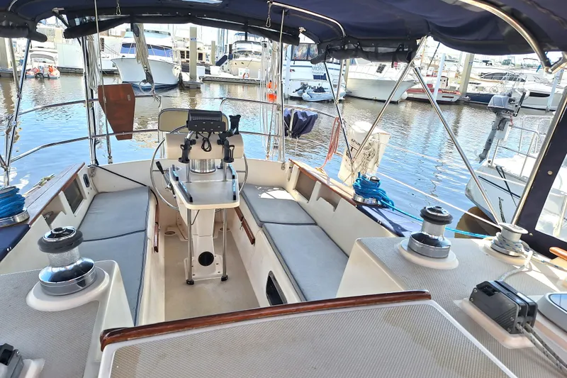 Slide: The Image of 1996 Island Packet 40 sailboat cockpit with seating, steering wheel, and marina view. - 36