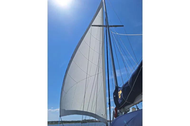 Slide: The Image of 1996 Island Packet 40 sailboat with sails unfurled under blue sky. - 47