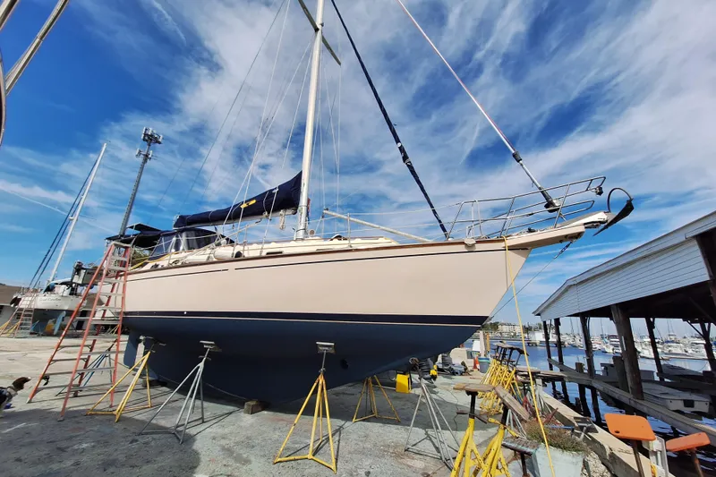 Slide: The Image of 1996 Island Packet 40 sailboat on dry dock, blue sky background, marina setting. - 49