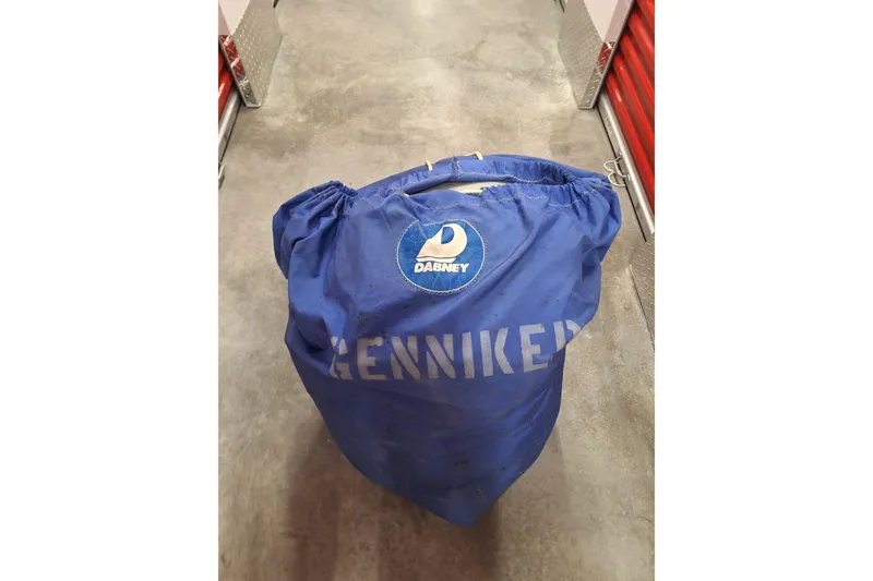 Slide: The Image of Blue sail bag labeled "GENNAKER" on concrete floor, related to 1996 Island Packet 40. - 54