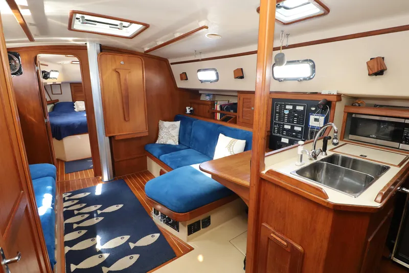 Slide: The Image of Interior of 1996 Island Packet 40 yacht with blue seating and wooden finishes. - 6