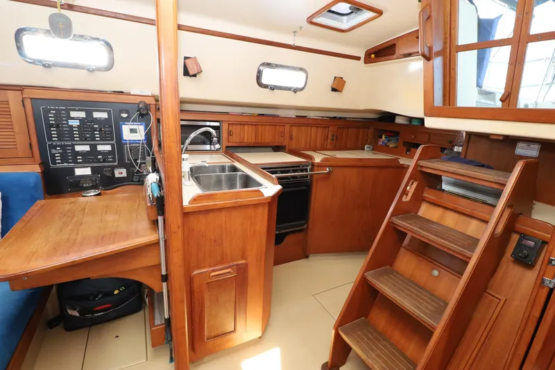 Slide: The Image of Interior of a 1996 Island Packet 40 sailboat with wooden cabinetry and navigation equipment. - 7