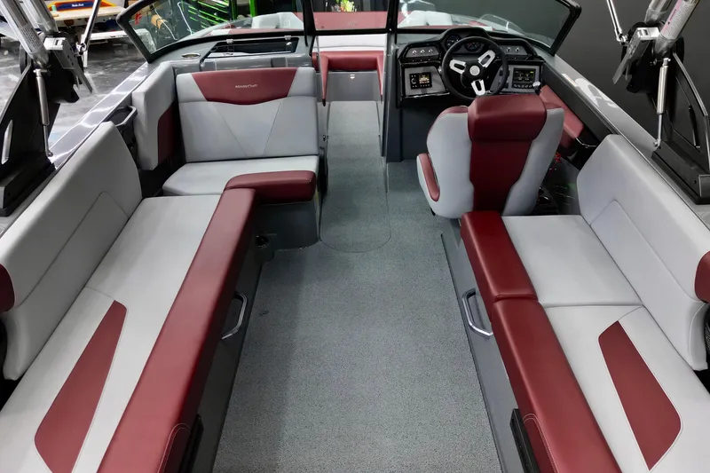 Slide: The Image of 2023 MasterCraft NXT24 boat interior with red and white seating, modern dashboard. - 11