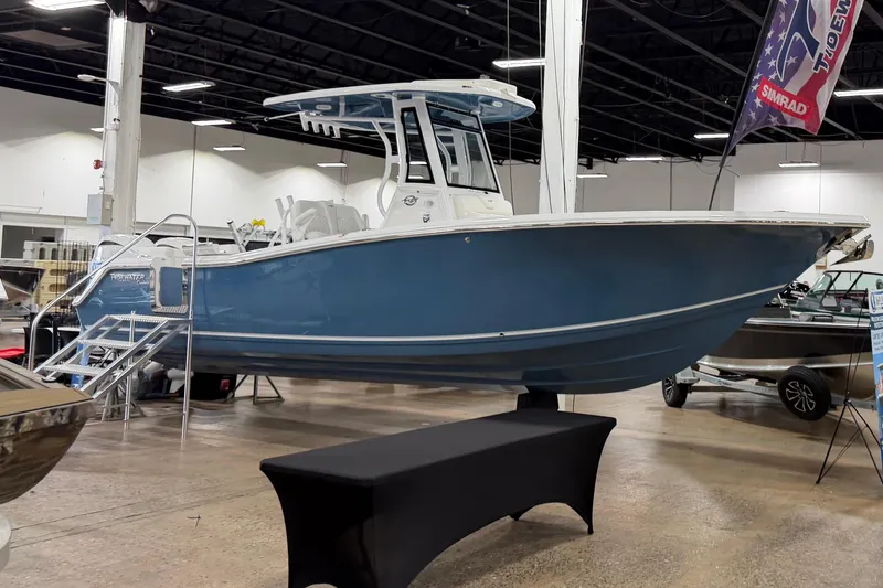 The Image of 2026 Tidewater 272 LXF boat displayed indoors, featuring a sleek blue hull and modern design. - 0