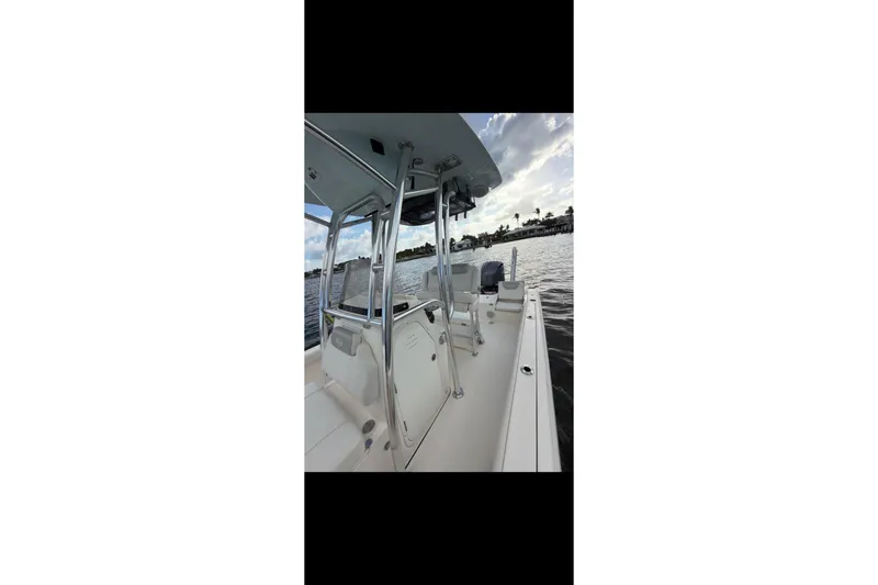 Slide: The Image of 2023 Key West 250 Bay Reef boat on calm water, showcasing sleek design and spacious deck. - 11