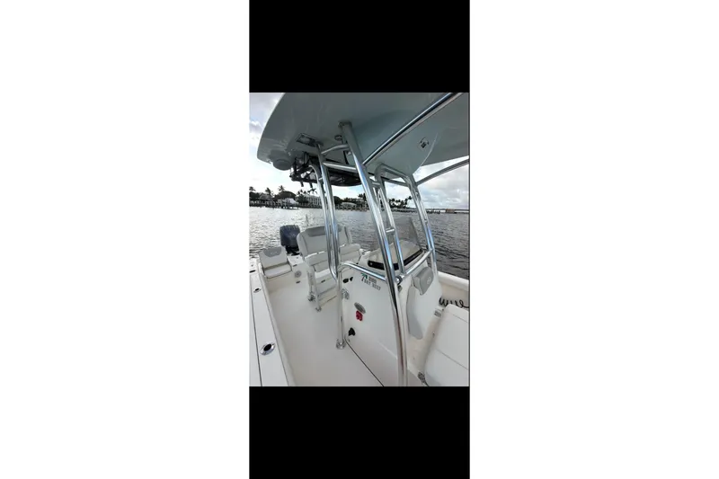 Slide: The Image of 2023 Key West 250 Bay Reef boat interior with seating and console on water. - 12