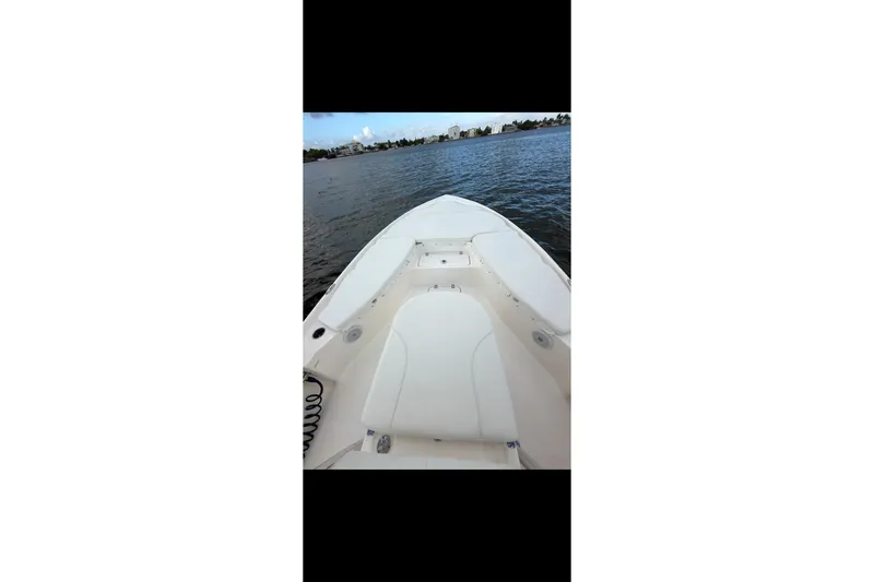 Slide: The Image of 2023 Key West 250 Bay Reef boat on calm water, showcasing spacious deck. - 3