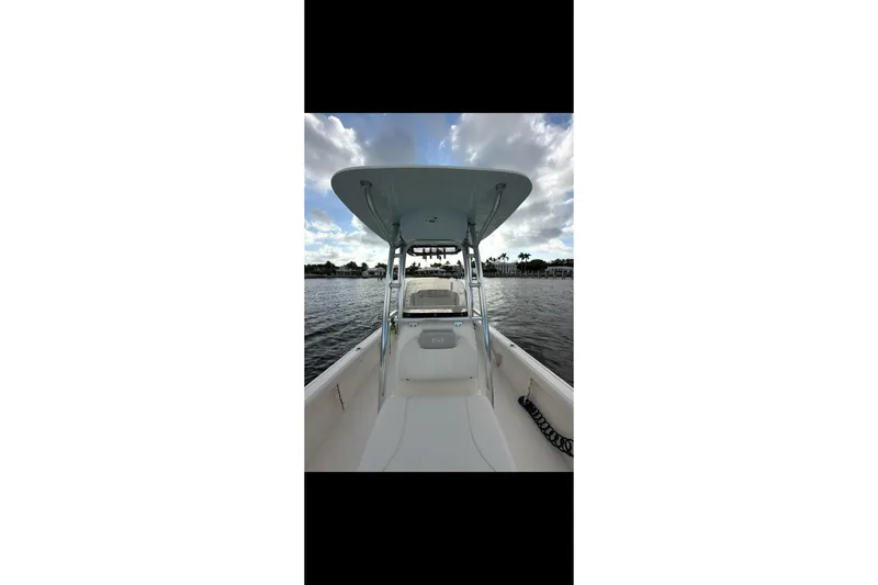 Slide: The Image of 2023 Key West 250 Bay Reef boat on calm water under cloudy sky. - 5