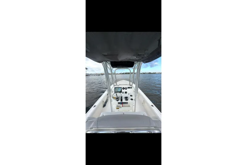 Slide: The Image of 2023 Key West 250 Bay Reef boat interior with steering console on water. - 7