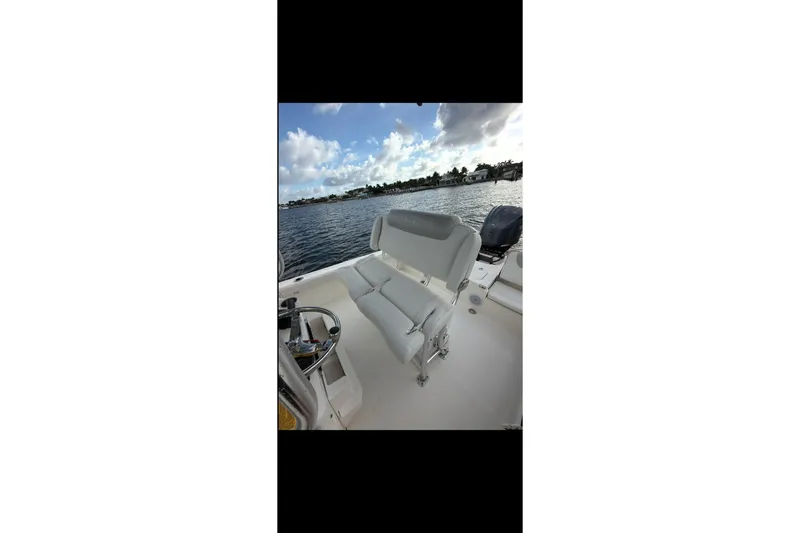 Slide: The Image of 2023 Key West 250 Bay Reef boat interior with seating, on calm water. - 9