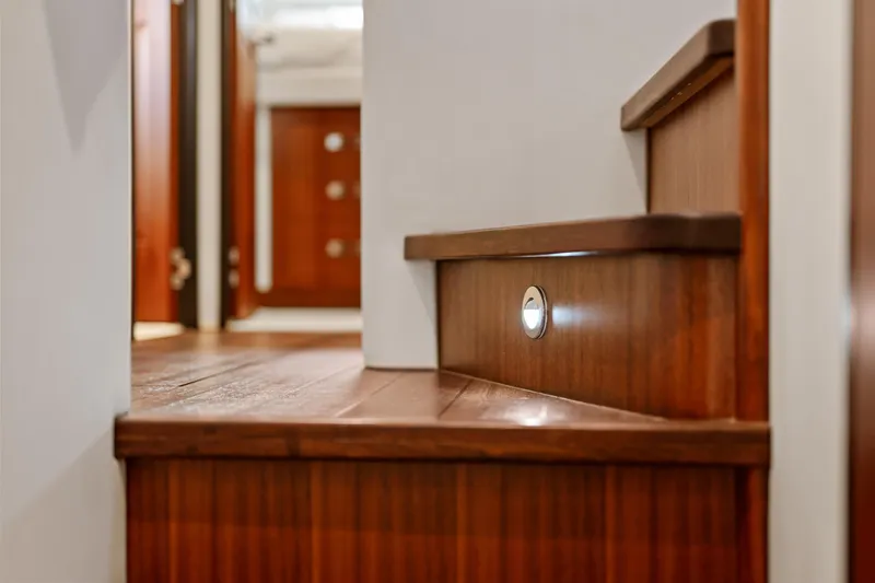 Slide: The Image of Wooden staircase with built-in lighting on a 2013 Hatteras 60 Motor Yacht. - 29