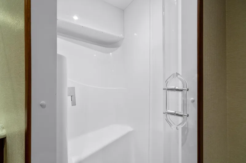 Slide: The Image of Shower area inside 2013 Hatteras 60 Motor Yacht, featuring sleek white design and modern fixtures. - 47