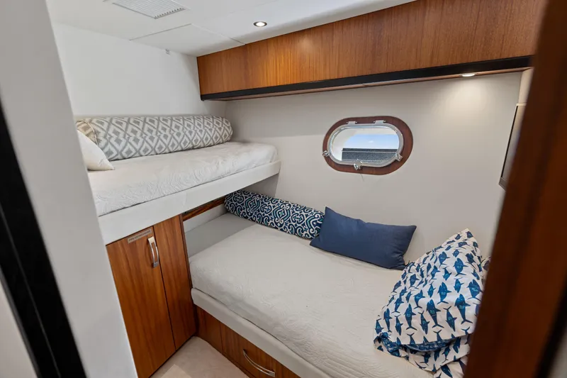 Slide: The Image of Cozy cabin interior of 2013 Hatteras 60 Motor Yacht with bunk beds and porthole window. - 50