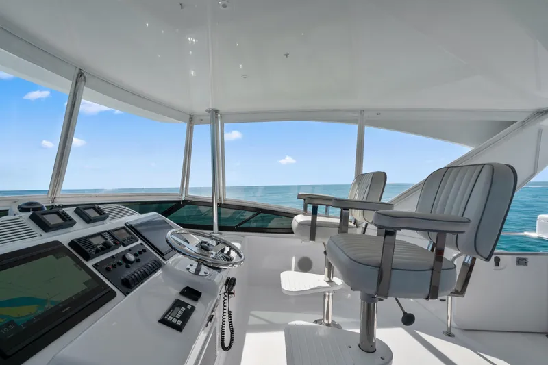Slide: The Image of Helm of 2013 Hatteras 60 Motor Yacht with ocean view and modern controls. - 62