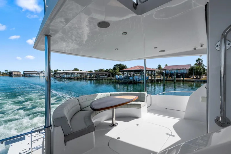 Slide: The Image of 2013 Hatteras 60 Motor Yacht aft deck with seating and waterfront view. - 67