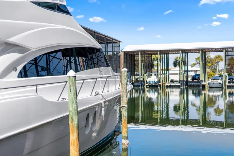 Slide: The Image of 2013 Hatteras 60 Motor Yacht docked at marina under clear blue sky. - 7