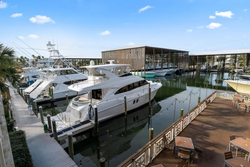 Slide: The Image of 2013 Hatteras 60 Motor Yacht docked at a marina with clear blue skies. - 74