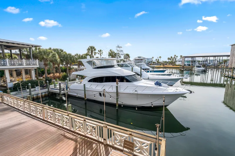 Slide: The Image of 2013 Hatteras 60 Motor Yacht docked at a marina under a clear blue sky. - 75