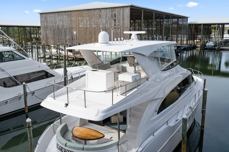 Slide: The Image of 2013 Hatteras 60 Motor Yacht docked at marina, showcasing sleek design and spacious deck. - 76